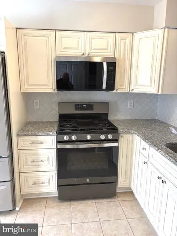 a kitchen with granite countertop a stove and a microwave