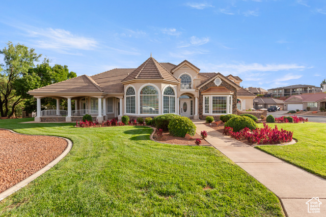 View of front of home with a front yard, a tiled roof, and stucco siding