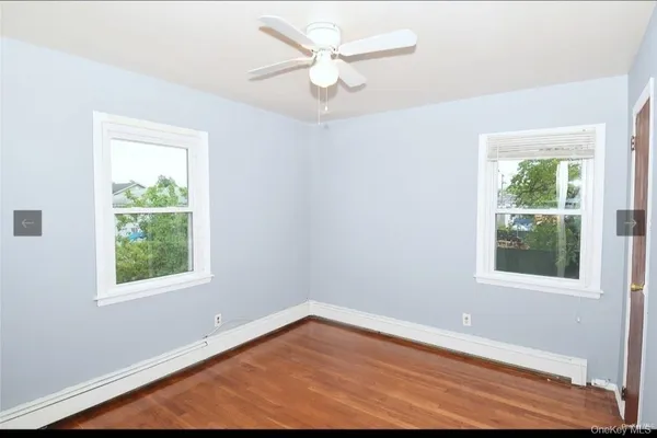 an empty room with a window and a ceiling fan