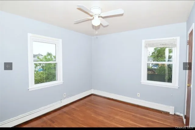 an empty room with a window and a ceiling fan