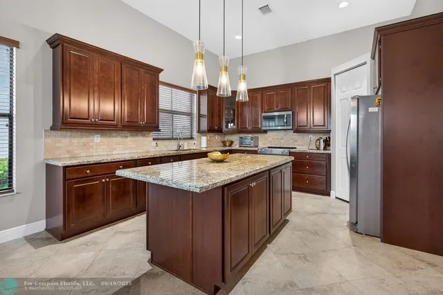 a kitchen with stainless steel appliances granite countertop a sink stove and refrigerator