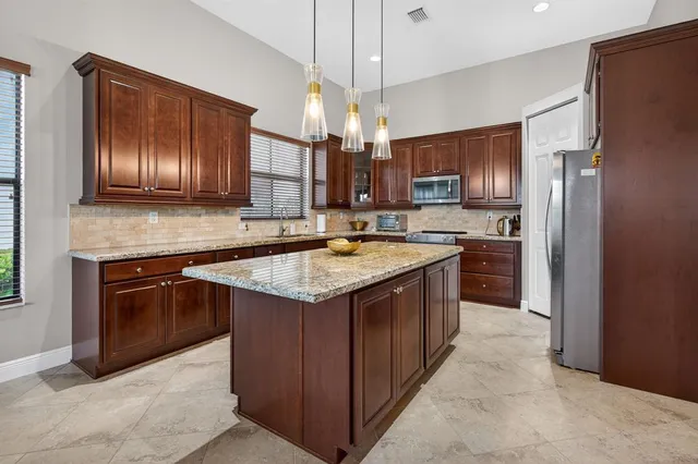 a kitchen with stainless steel appliances granite countertop wooden cabinets a stove top oven a sink and dishwasher