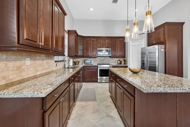 a kitchen with granite countertop wooden cabinets and stainless steel appliances