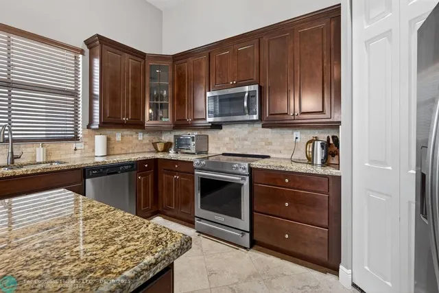 a kitchen with granite countertop wooden cabinets and stainless steel appliances