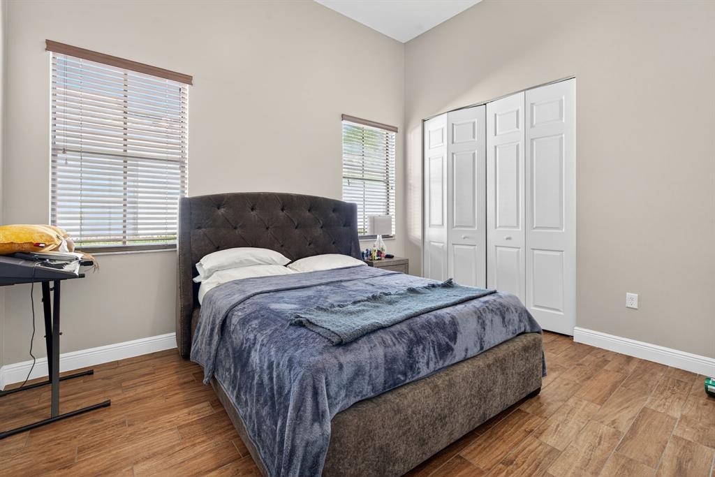 5294 Ferrari Avenue Ave Maria, FL 34142 - Photo 23 of 42 a bedroom with a bed and wooden floor