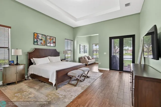 a spacious bedroom with a bed and wooden floor