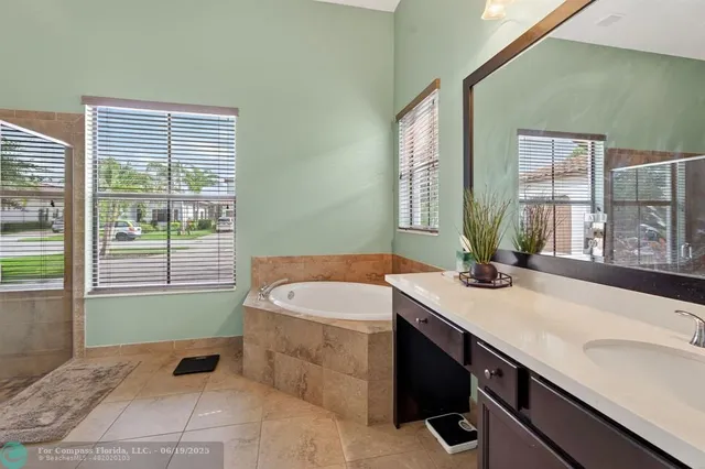 a bathroom with a granite countertop sink and a bathtub