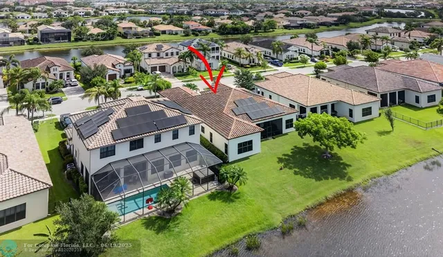 an aerial view of residential houses with outdoor space and lake view