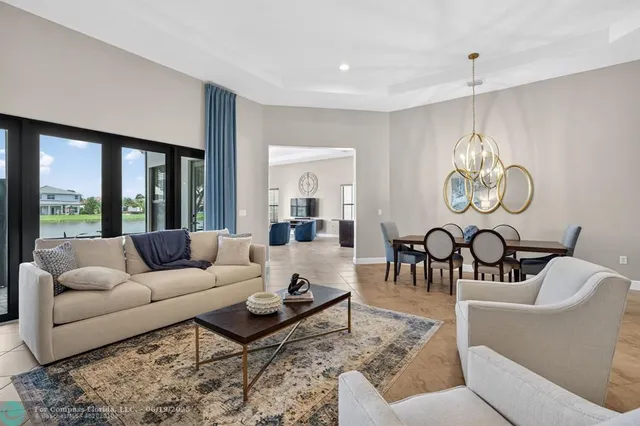 a living room with furniture chandelier and a large window