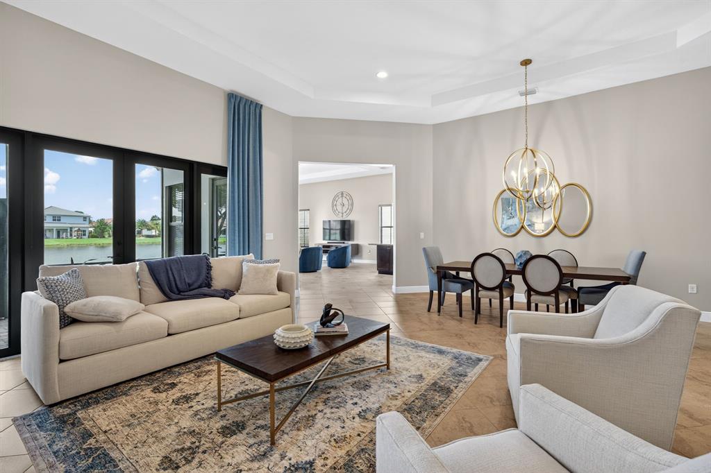 5294 Ferrari Avenue Ave Maria, FL 34142 - Photo 7 of 42 a living room with furniture chandelier and a large window