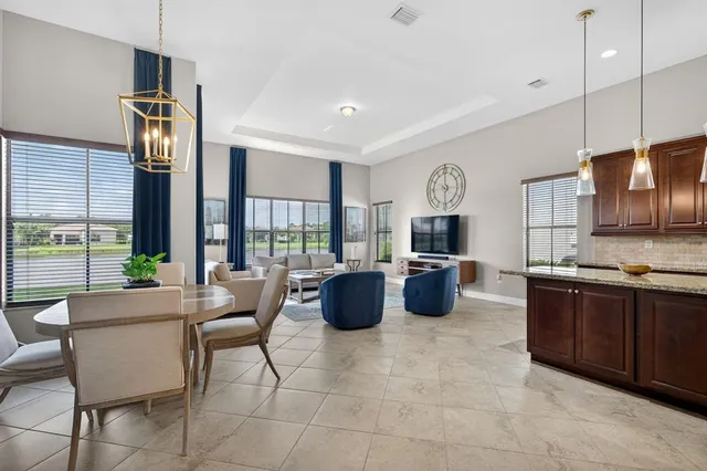 a dining room with furniture and large windows