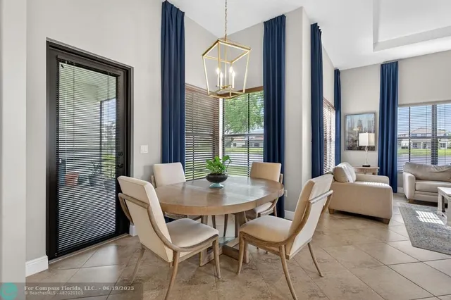 a dining room with furniture and large windows