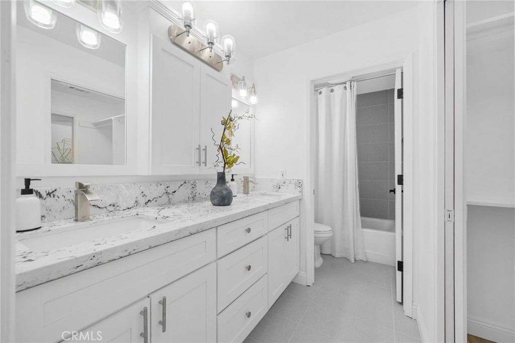 5087 Granada Court Rancho Cucamonga, CA 91737 - Photo 27 of 49 a bathroom with a double vanity sink and a mirror
