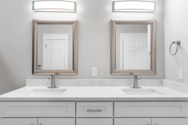 a bathroom with double vanity sink and a mirror