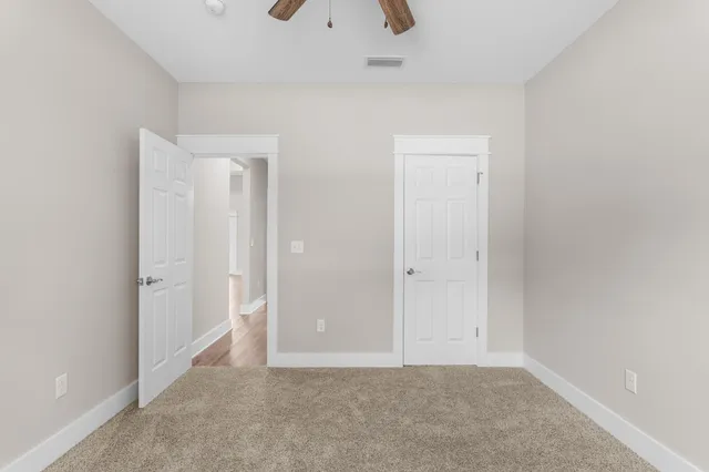 an empty room with a window and a ceiling fan