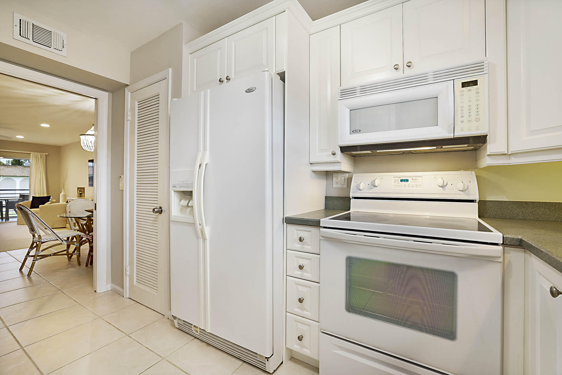 755 Saturn Street, Unit F203 Jupiter, FL 33477 - Photo 20 of 36 a kitchen with white cabinets and appliances