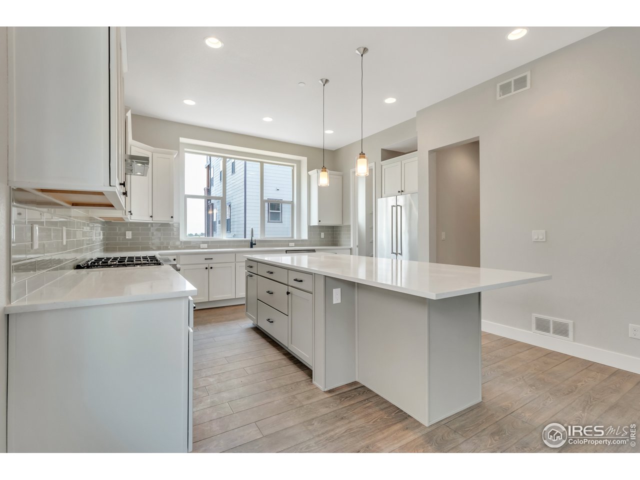 587 Canary Lane Superior, CO 80027 - Photo 20 of 22 a kitchen with a sink a stove a refrigerator and white cabinets