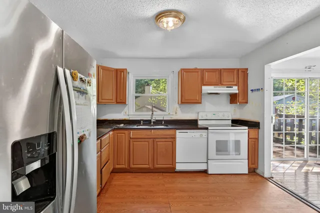 a kitchen with stainless steel appliances granite countertop a stove a sink and a refrigerator