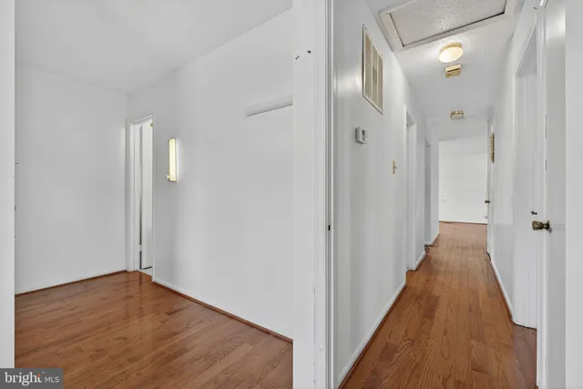 a view of a hallway with wooden floor