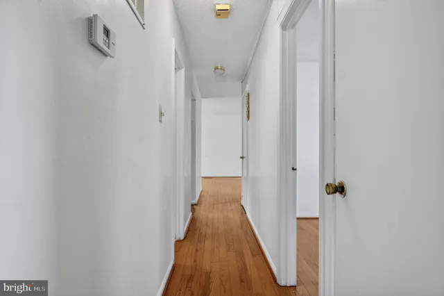 a view of a hallway with wooden floor and staircase