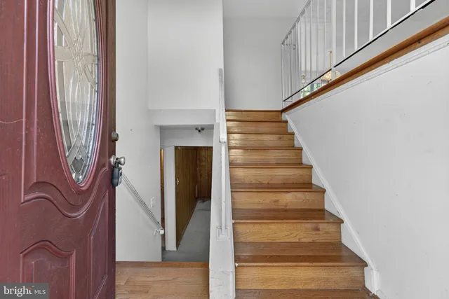 a view of staircase with white walls and railing
