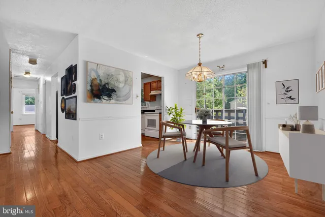 a dining room with furniture a chandelier and wooden floor
