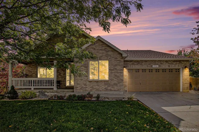 a front view of a house with a garden and yard
