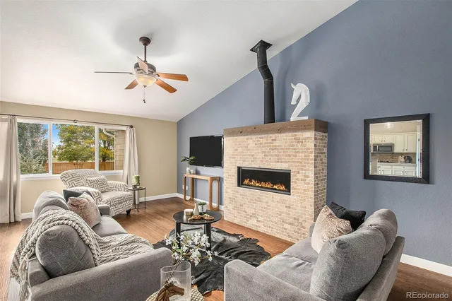 a living room with furniture ceiling fan and a flat screen tv
