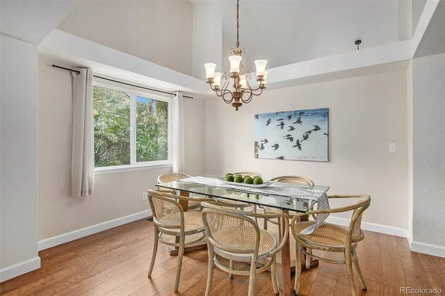 a dining room with furniture a chandelier and wooden floor