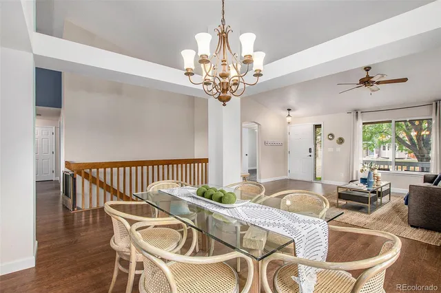 a dining room with furniture a chandelier and wooden floor