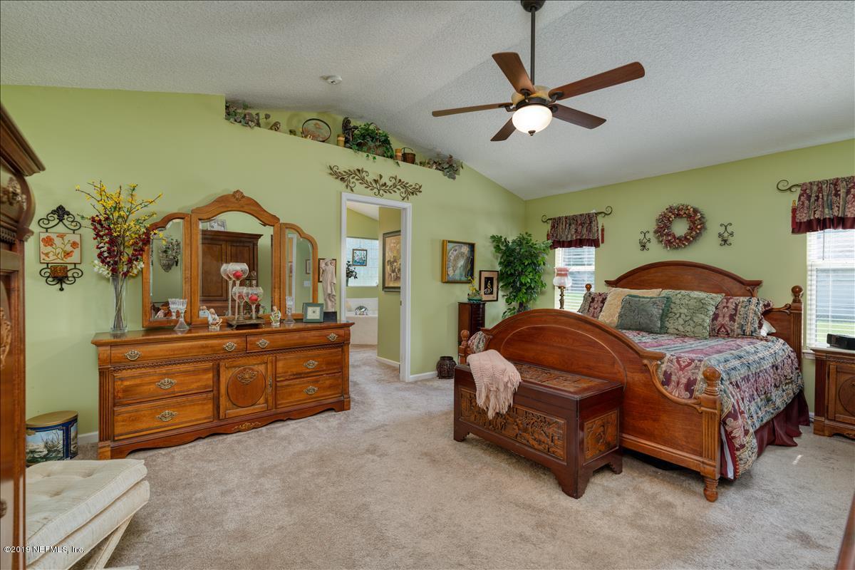 1372 Blackmon Road Green Cove Springs, FL 32043 - Photo 16 of 26 a bedroom with a bed and a chandelier