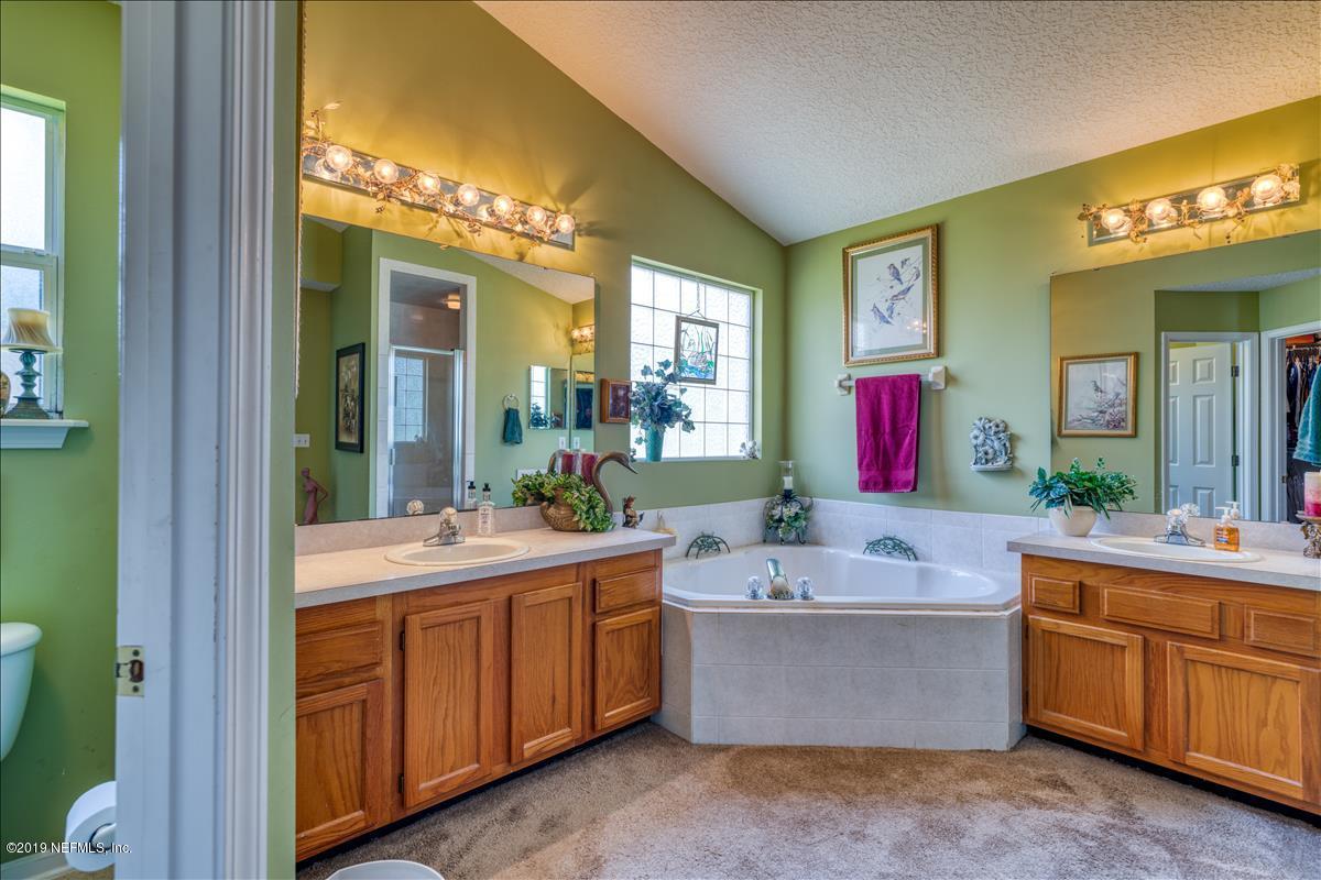 1372 Blackmon Road Green Cove Springs, FL 32043 - Photo 18 of 26 a bathroom with a tub sink and mirror