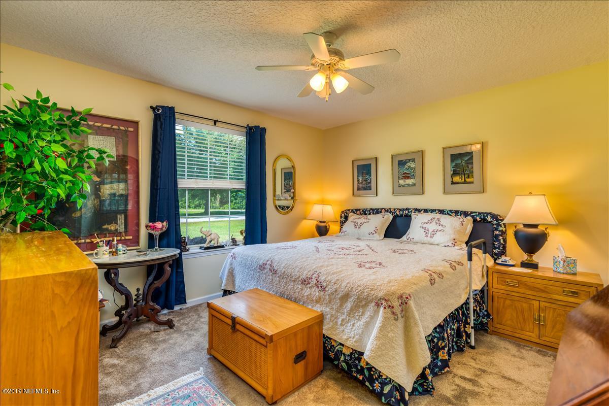 1372 Blackmon Road Green Cove Springs, FL 32043 - Photo 20 of 26 a bedroom with a bed and a chandelier