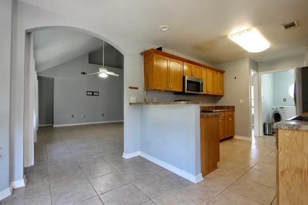 a kitchen with stainless steel appliances granite countertop a stove a sink and a microwave