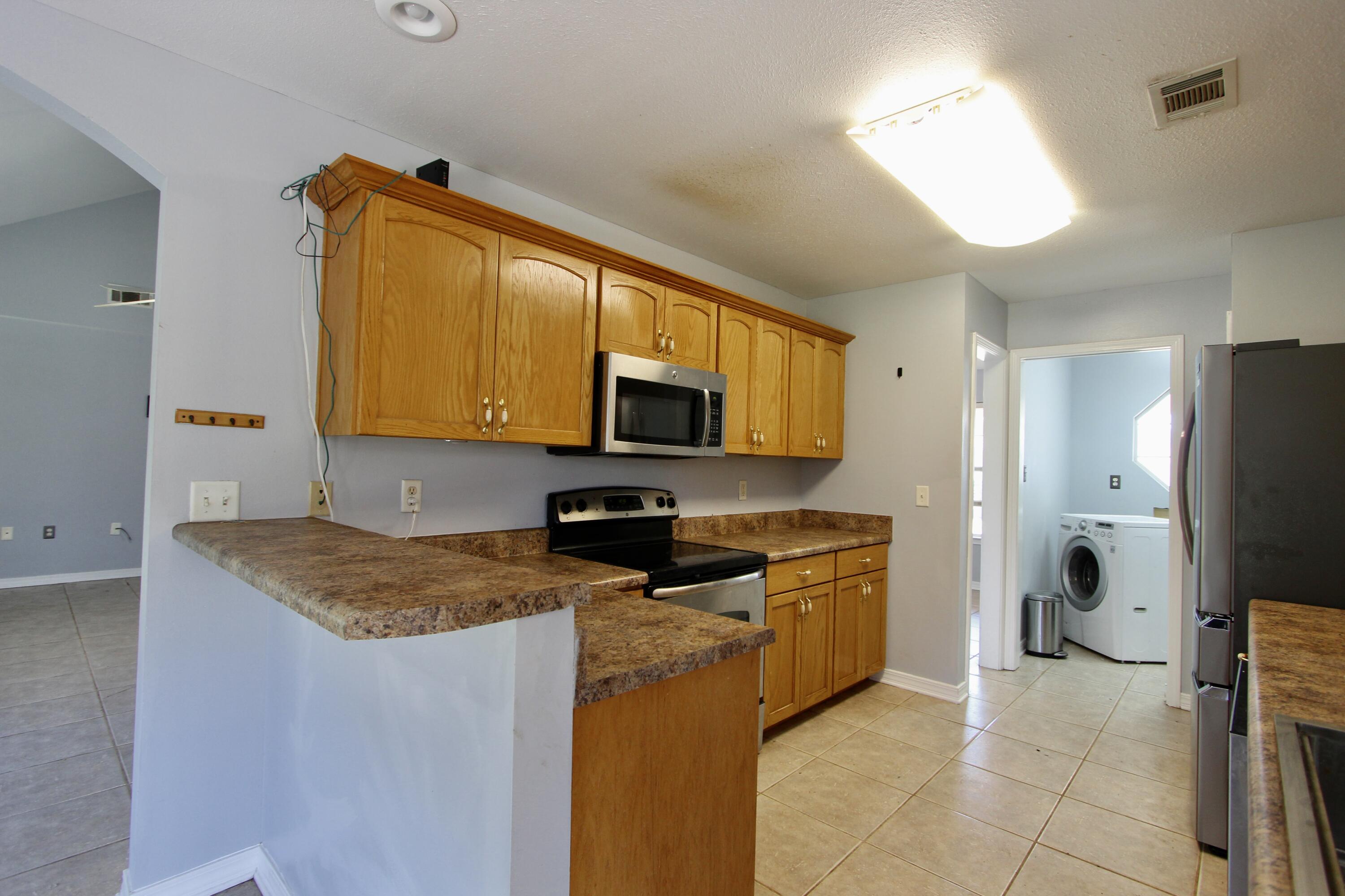6064 Buckward Road Baker, FL 32531 - Photo 14 of 34 a kitchen with stainless steel appliances granite countertop a sink refrigerator and microwave