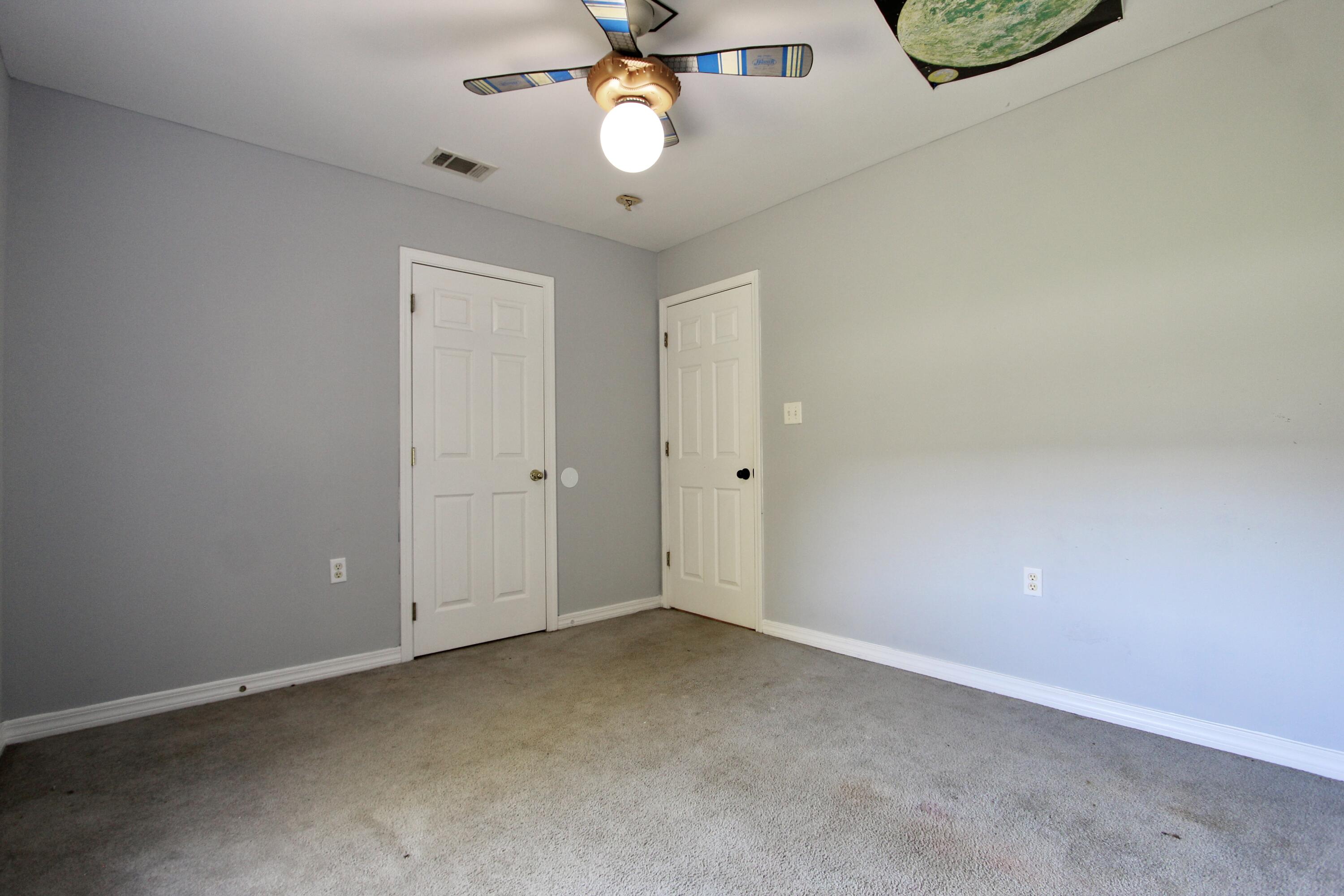 6064 Buckward Road Baker, FL 32531 - Photo 19 of 34 an empty room with chandelier fan and windows