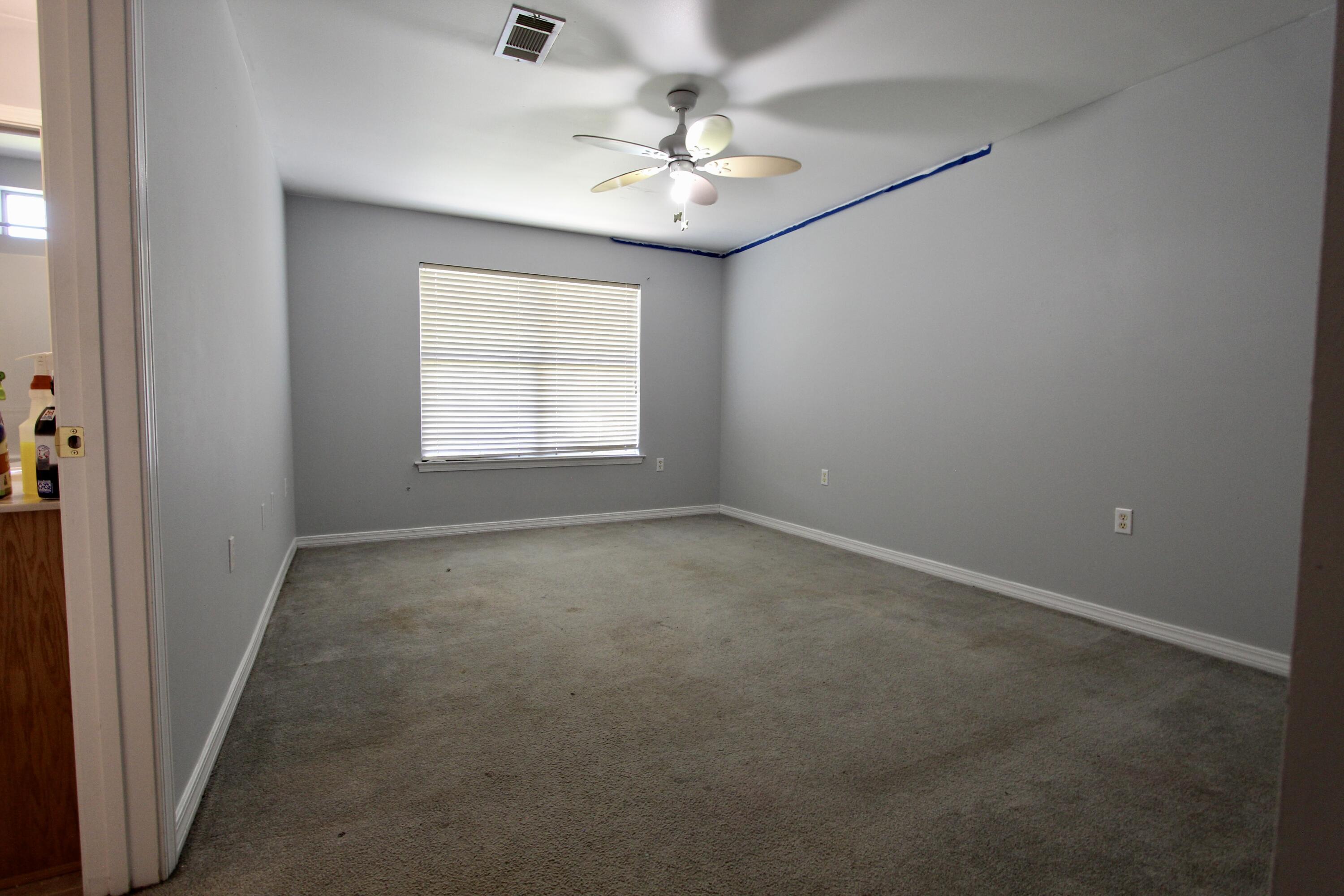6064 Buckward Road Baker, FL 32531 - Photo 24 of 34 an empty room with windows and chandelier fan