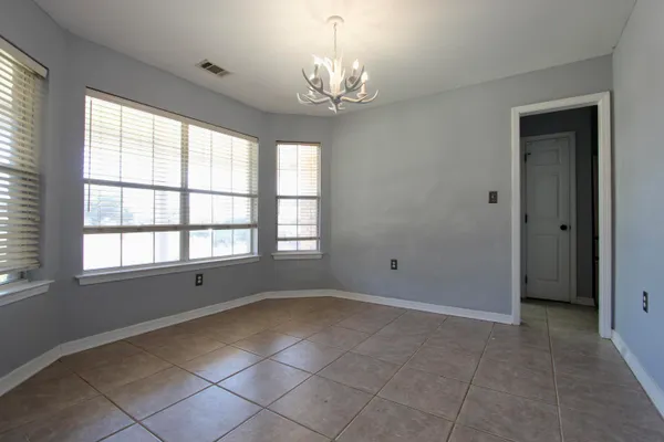 a view of a hallway with wooden floor and windows