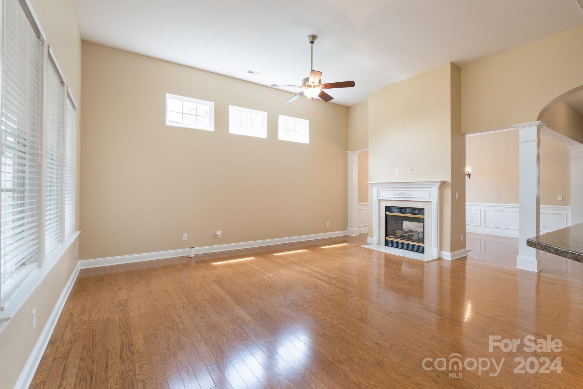 1385 Secret Path Drive Fort Mill, SC 29708 - Photo 11 of 48 an empty room with wooden floor fireplace and windows
