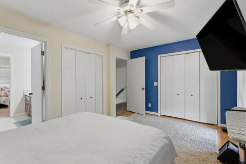 a bedroom with a bed and a flat tv screen on dresser