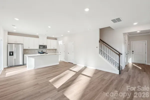a view of kitchen with granite countertop refrigerator oven a white stove with cabinets and wooden floor