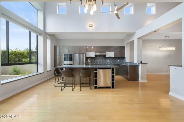 a kitchen with stainless steel appliances granite countertop a sink and a refrigerator