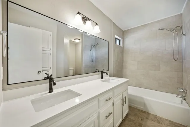 a bathroom with a sink a toilet a mirror and shower