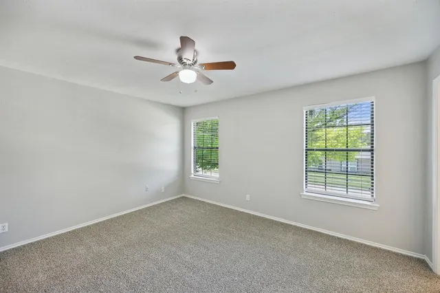 an empty room with a window and a fan