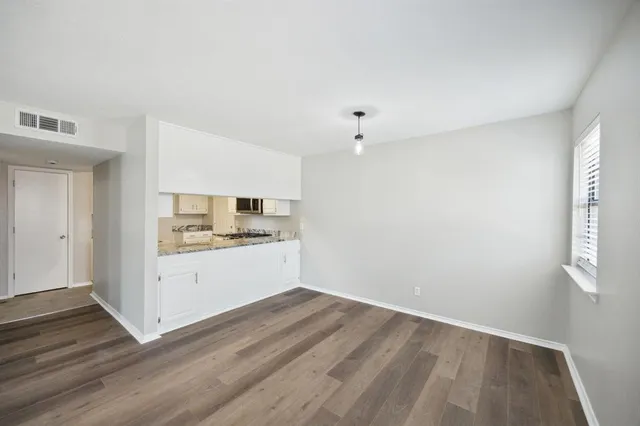 a view of a kitchen with wooden floor and electronic appliances