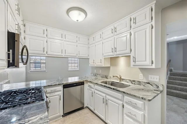 a kitchen with stainless steel appliances granite countertop a sink stove and cabinets