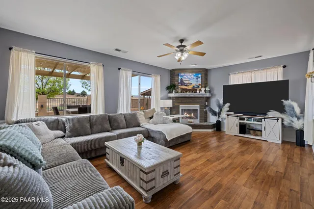 a living room with furniture a flat screen tv and a large window