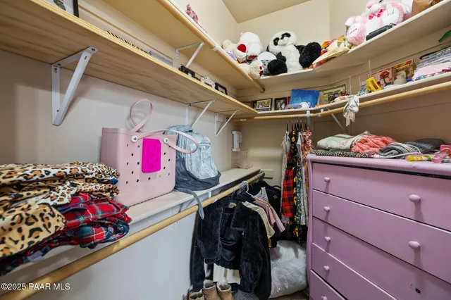 a view of walk in closet with clothes and shoes