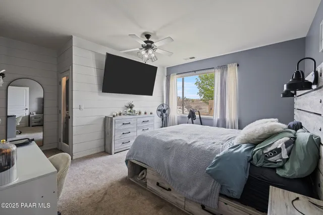 a bedroom with a bed and a flat screen tv