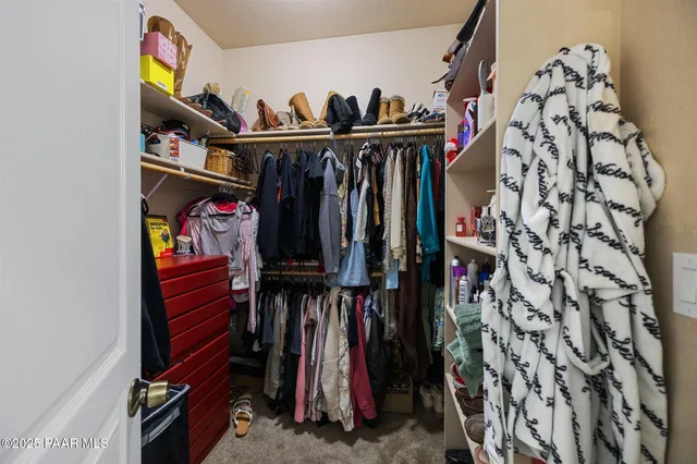 a view of walk in closet with clothes